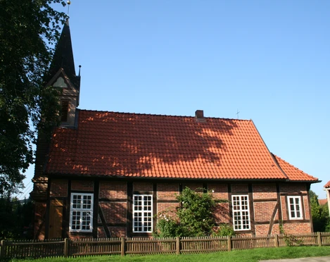 Fachwerkkapelle Anderten Fachwerkkapelle in Anderten mit rotem Ziegeldach und umgebender Holzzaun vor blauem Himmel.