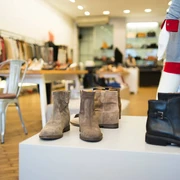 PREGO  Das Bild zeigt moderne Schuhe und Stiefel in einer stilvollen Boutique auf hölzernem Boden präsentiert.The picture shows modern shoes and boots presented in a stylish boutique on a wooden floor.