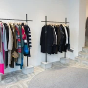 MATA Cologne Innenansicht eines Modegeschäfts mit bunten und neutralen Kleidungsstücken auf Kleiderstangen.Interior view of a fashion store with colorful and neutral garments on clothes rails.