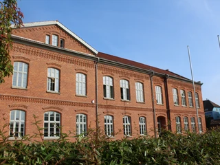Nds. Polizeiakademie Historisches Backsteingebäude der Polizeiakademie Niedersachsen mit blauen Himmel im Hintergrund.