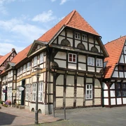 Altstadt Nienburg Fachwerkhäuser in Nienburg mit roten Ziegeldächern vor blauem Himmel und Kopfsteinpflasterweg.