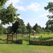 Kinderwildnis Nienburg Grüne Kinderwildnis mit Spielplatz und Bäumen, umgeben von natürlicher Vegetation in Nienburg.