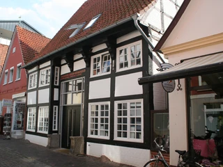 Traufenhaus Weserstraße Nienburg Fachwerkhaus in der Weserstraße Nienburgs mit roten Dachziegeln und schwarz-weißen Balkenstrukturen.