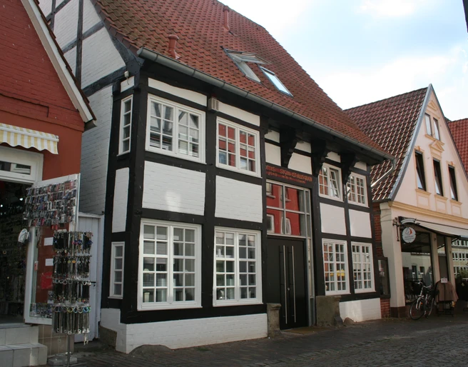 Traufenhaus Weserstraße Nienburg Ein traditionelles Fachwerkhaus mit weißer Fassade und schwarzem Gebälk in der Weserstraße Nienburg.
