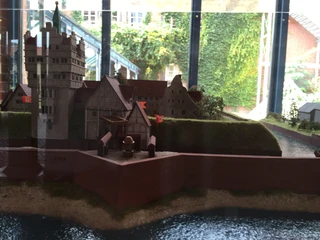 Schlossmodell im Rathaus Nienburg Ein detailliertes Modell eines historischen Schlosses, umgeben von Wasser und Grünflächen, im Rathaus Nienburg.