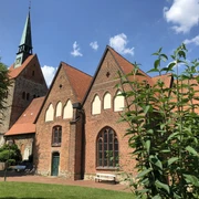 Kirche Vilsen Backsteinkirche in sommerlicher Umgebung mit Fachwerkelementen und einem markanten Kirchturm.