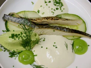 Brasserie Capricorn i Aries Ein Fischfilet künstlerisch auf einem Teller mit verschiedenen Soßen angerichtet.A fish fillet artistically arranged on a plate with various sauces.