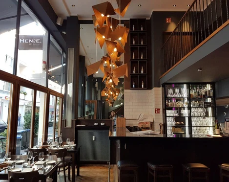 Henne Weinbar Innenansicht vom Restaurant auf eine künstlerische Hängelampe aus kupfernem Metall hergestellt.Interior view of the restaurant looking up at an artistic hanging lamp made of copper metal.