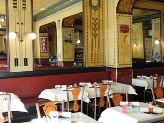 Le Moissonnier Restaurant Innenansicht, Interieur und Wände im Jugendstil mit warmen, gelben Farben.Restaurant interior view, interior and walls in Art Nouveau style with warm, yellow colors.