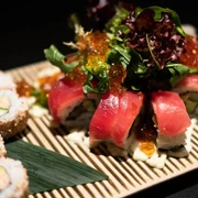 Zen Eine Auswahl an Sushi, darunter Nigiri und Maki, sorgfältig auf einem Bambusbrett arrangiert.A selection of sushi, including nigiri and maki, carefully arranged on a bamboo platter.