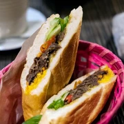 Cafe 1980 Bunt gefülltes Baguette-Sandwich mit frischem Gemüse in einem pinken Korb.Colorful filled baguette sandwich with fresh vegetables in a pink basket.