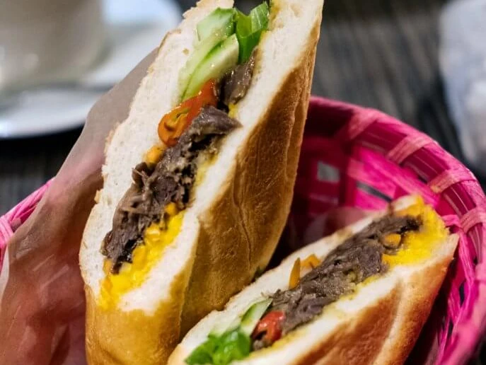 Cafe 1980 Bunt gefülltes Baguette-Sandwich mit frischem Gemüse in einem pinken Korb.Colorful filled baguette sandwich with fresh vegetables in a pink basket.