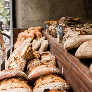 prôt Eine rustikale Brotauslage zeigt eine Vielfalt frischer Brote, darunter Krustenbrote und Körnerstangen.A rustic bread display showcases a variety of fresh breads, including crusty loaves and grain sticks.