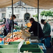 Wochenmarkt auf dem Neptunplatz Marktstände auf dem Neptunplatz in Köln unter einem großen Pavillon. Menschen kaufen frisches Obst und Gemüse.Market stalls on Neptunplatz in Cologne under a large pavilion. People buy fresh fruit and vegetables.