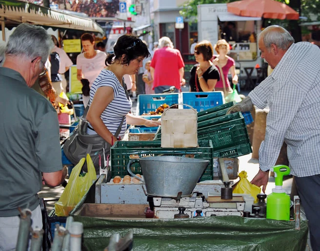 Farmers’ market in Deutz Marktszene mit Menschen, die frisches Obst und Gemüse an einem Kölner Stand begutachten und einkaufen.Market scene with people inspecting and buying fresh fruit and vegetables at a stall in Cologne.