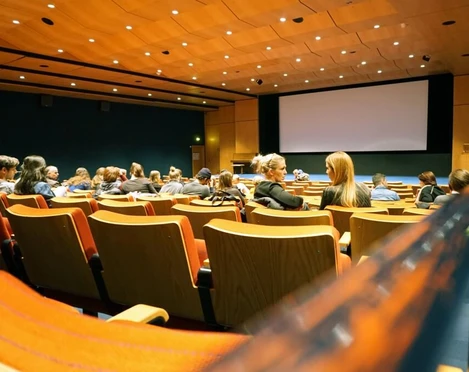 Filmforum NRW Innenansicht eines Kinosaals mit Sitzen, einer großen Leinwand und PublikumInterior view of a movie theater with seats, a large screen and an audience