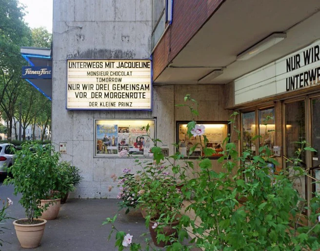 Weisshauskino Eingangsbereich des Weisshauskinos mit Leuchtreklame und PflanzenEntrance area of the Weisshaus cinema with neon sign and plants