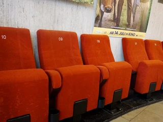 Weisshauskino Reihe von sechs roten Kinosesseln mit NummerierungRow of six red movie theater seats with numbering
