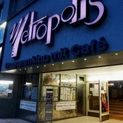 Metropolis Das Bild zeigt das Metropolis Kino, ein charmantes Programmkino mit angeschlossenem Café. Die leuchtende Fassade zieht mit ihrem markanten Schriftzug die Aufmerksamkeit der Besucher auf sich.The picture shows the Metropolis Kino, a charming arthouse cinema with an adjoining café. The bright façade attracts the attention of visitors with its striking lettering.