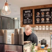 Haferkater Blick in das Bistro auf eine Espressomaschine und Kreidetafeln an der Wand.View of an espresso machine and chalk boards on the wall in the bistro.
