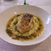 Wackes Ein Teller mit gebratenem Fischfilet auf cremigem Kartoffelpüree, garniert mit Kapern und Kräutern.A plate with pan-fried fish fillet served on creamy mashed potatoes, garnished with capers and herbs.
