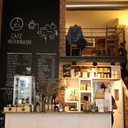 Wohnraum Café mit Ziegelwänden, Kreidetafel-Menüs und einladendem Ambiente im Wohnraum-Stil.Café with brick walls, chalkboard menus, and an inviting, home-like atmosphere.