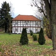 Amtshaus Wölpe Das Bild zeigt ein historisches Fachwerkhaus im Grünen mit kleinen Koniferen im Vordergrund.