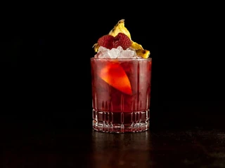Bar Little Link Ein roter Cocktail elegant in Szene gesetzt vor einem schwarzen Hintergrund.A red cocktail elegantly presented against a black background.