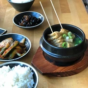 Restaurant Anju, Tapas Koreanische Speisen in kleinen Schüsseln, Gurkensalat, Reise und Teigtaschen.Korean dishes in small bowls, cucumber salad, rice and dumplings.
