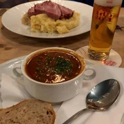 Pütz Brewery Ein köstliches Gericht aus herzhaftem Gulasch und Brot, begleitet von einem erfrischenden Bier.A delicious dish of hearty goulash and bread, accompanied by a refreshing beer.