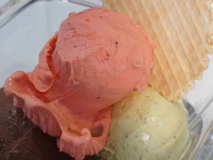 IL GELATO di ferigo Nahaufnahme von drei Kugeln Eiscreme mit runder Waffel.Close-up of three scoops of ice cream with a round cone.