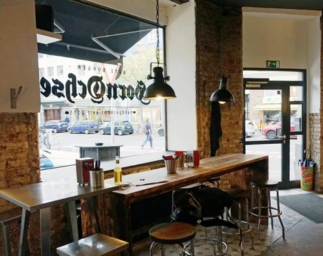 Burger Restaurant Hornochse Im industriellen Stil eingerichtetes Restaurant mit Backsteinwand und metallischen Hängeleuchten.Restaurant furnished in an industrial style with brick wall and metallic pendant lights.