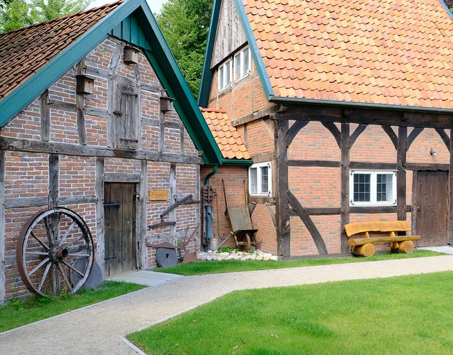 DSCF1618_klein.jpg Altes Bauernhaus mit Fachwerk, Holztür und grünem Gartenweg.