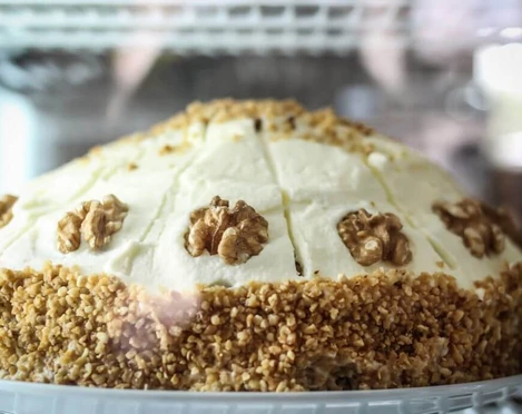 KAFFEEBUD Nahaufnahme einer Torte mit Walnuss.Closeup of a pie with a walnut on top.