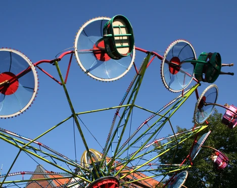 Altstadtfest Nienburg Ein buntes Riesenrad mit drehbaren Gondeln vor strahlend blauem Himmel während des Altstadtfests.