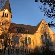Kirche Frille Eine historische Kirche mit markantem Turm leuchtet im warmen Licht der Abendsonne.