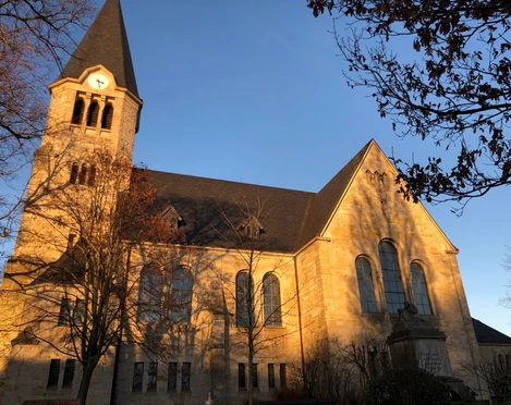 Kirche Frille Eine historische Kirche mit markantem Turm leuchtet im warmen Licht der Abendsonne.