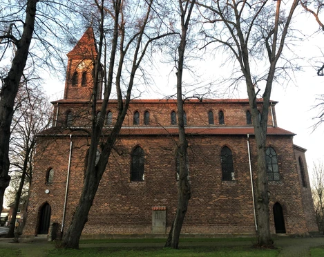 Kirche Friedewalde Backsteinkirche aus dem 13. Jahrhundert mit hohen Fenstern und mittelalterlichem Turm, umgeben von Bäumen.