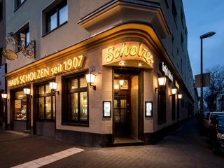 Restaurant Haus Scholzen Außenfassade vom Restaurant bei Abenddämmerung mit auffälliger Beleuchtung.Exterior facade of the restaurant at dusk with eye-catching lighting.