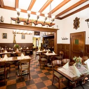 Restaurant Haus Scholzen Rustikal eingerichtetes Restaurant mit Holzbalken an der Decke und Bilder in goldenen Rahmen an den WändenRustic restaurant with wooden ceiling beams and paintings in golden frames on the walls