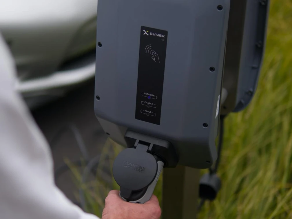 beispiel-e-mobilitaet_pexels-ed-harvey.JPG Ein Mann behandelt das Kabel einer Ladestation für Elektrofahrzeuge im Grünen.