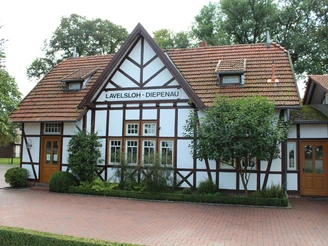 Hochzeitsbahnhof Lavelsloh Historischer Fachwerkbahnhof Lavelsloh mit roten Dachziegeln und zwei symmetrischen Eingangstüren.