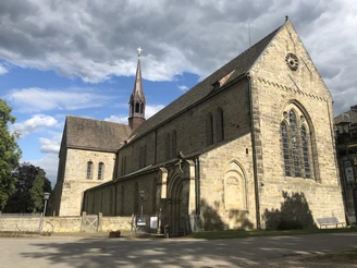 Das Kloster Loccum Alte Klostermauern in Loccum, bewölkter Himmel, markanter Kirchturm und gotische Fenster.