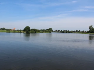 Dörverden Weser Im Vordergrund fließt die ruhige Weser entlang grüner Ufer, im Hintergrund zeigt sich offenes Land.