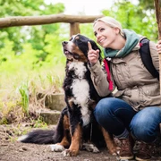 Mit Hund unterwegs, Foto:© Kzenon – stock.adobe Hiking woman with rucksack and her bernese mountain dog on a trail