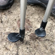 Nordic Walking Zwei Nordic-Walking-Stöcke stehen auf einem parkettähnlichen Weg, umgeben von Sportschuhen.