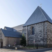St. George Romanische Kirche St. Georg mit Natursteinfassade und steilem Satteldach bei Tageslicht.Romanesque church of St. George with natural stone façade and steep pitched roof in daylight.