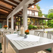 Landhotel Der Schwallenhof: Terrasse Weiß gedeckte Tische mit Kerzen und Blumen auf einer überdachten Terrasse mit Blick ins Grüne.