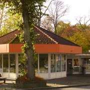 Tourist Information Bad Driburg  Tourist Information Bad Driburg, rundes Gebäude mit großen Fenstern, umgeben von herbstlichen Bäumen.