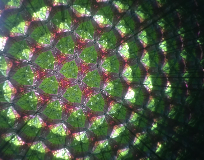 Im Zeitlupenkaleidoskop fließen Flüssigkeiten ganz langsam durch das Bild und verändern es so in Zeitlupe Farbenfrohes Kaleidoskop-Muster mit langsamer Bewegung, zeigt harmonische Anordnung sich wandelnder Formen.
